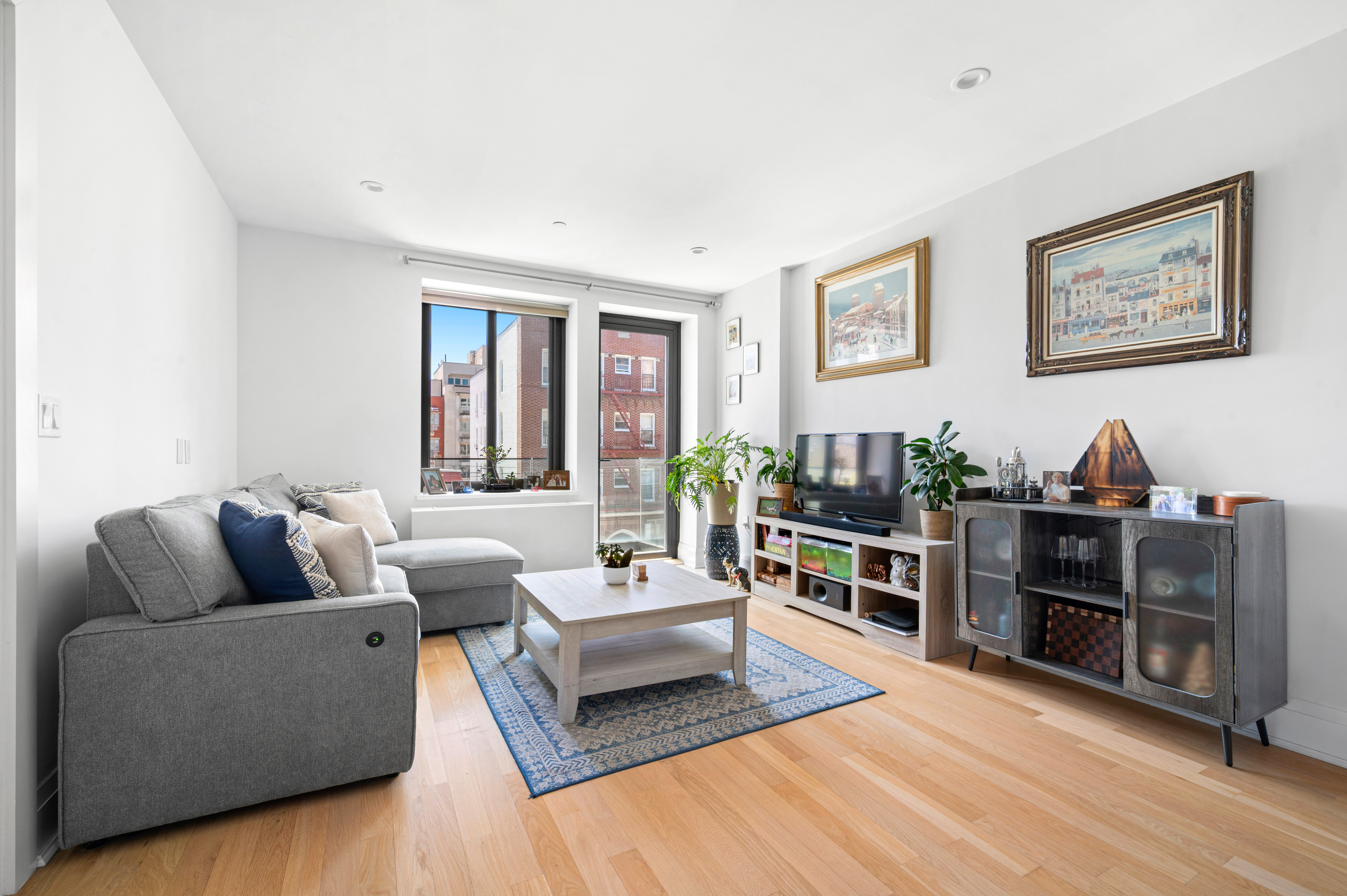 23-43 31st Road, Unit 3C Queens, NY 11106 - Photo 1 of 10 a living room with furniture and a flat screen tv