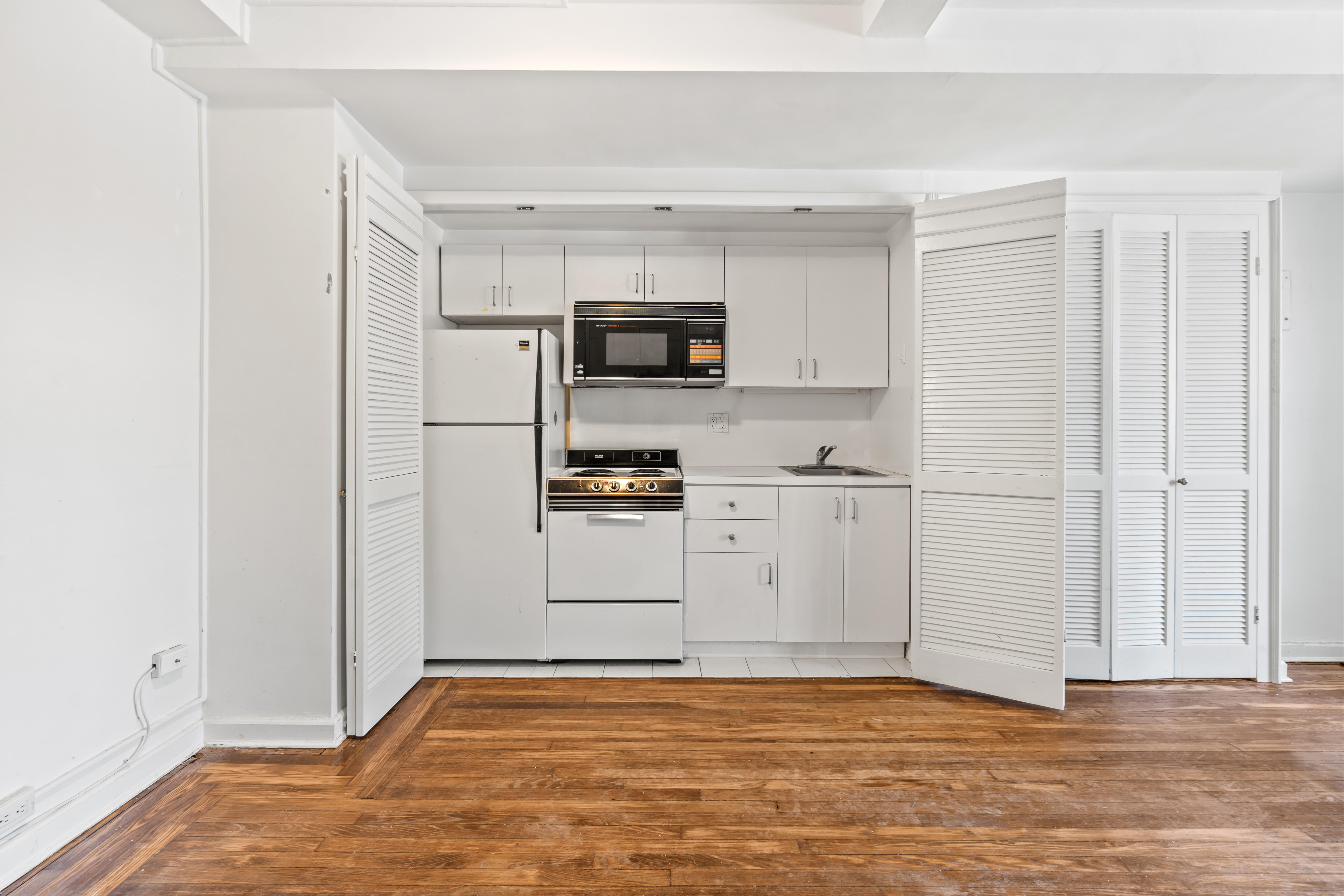 45 Tudor City Place, Unit 1708 Manhattan, NY 10017 - Photo 6 of 14 a view of kitchen with granite countertop cabinets and refrigerator