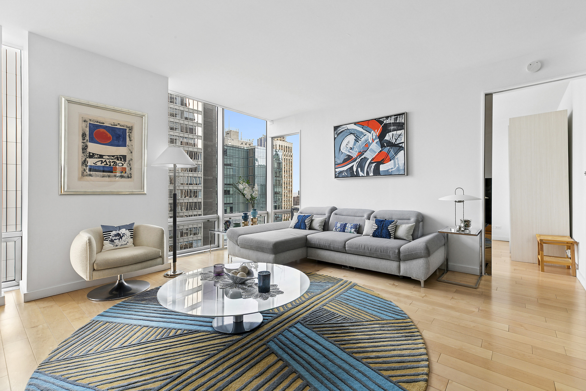 641 5th Avenue, Unit 28B Manhattan, NY 10022 - Photo 2 of 11 a living room with furniture and a wooden floor