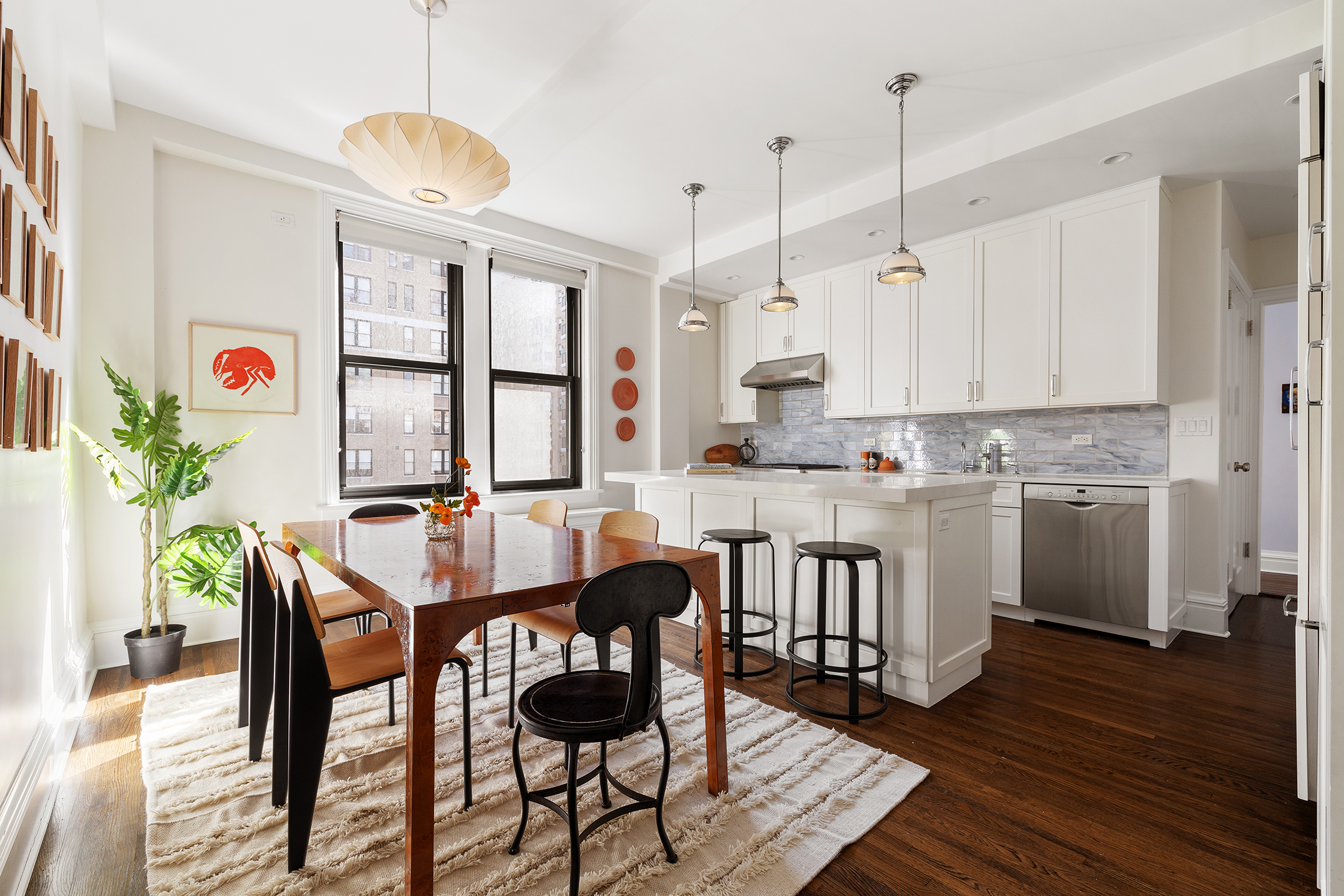 24 West 69th Street, Unit 9A Manhattan, NY 10023 - Photo 3 of 14 a kitchen with stainless steel appliances kitchen island a table and chairs in it