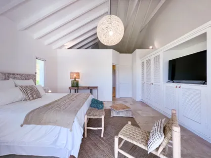 a bed room with a bed a television and a large window