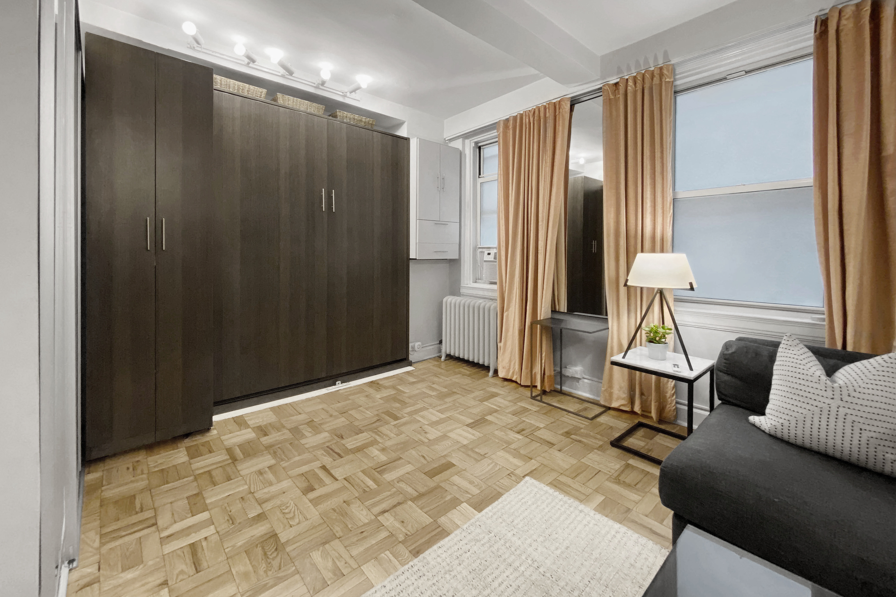 155 East 49th Street, Unit 1E Manhattan, NY 10017 - Photo 5 of 8 a bedroom with a bed and a chandelier