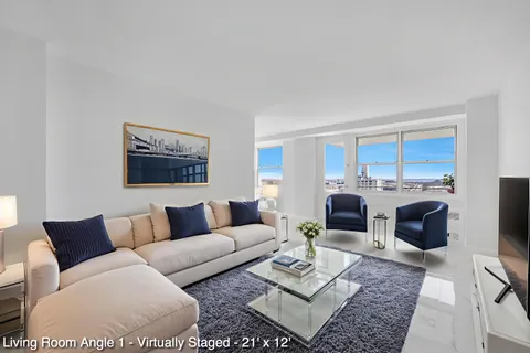 a living room with furniture a rug a fireplace and a window