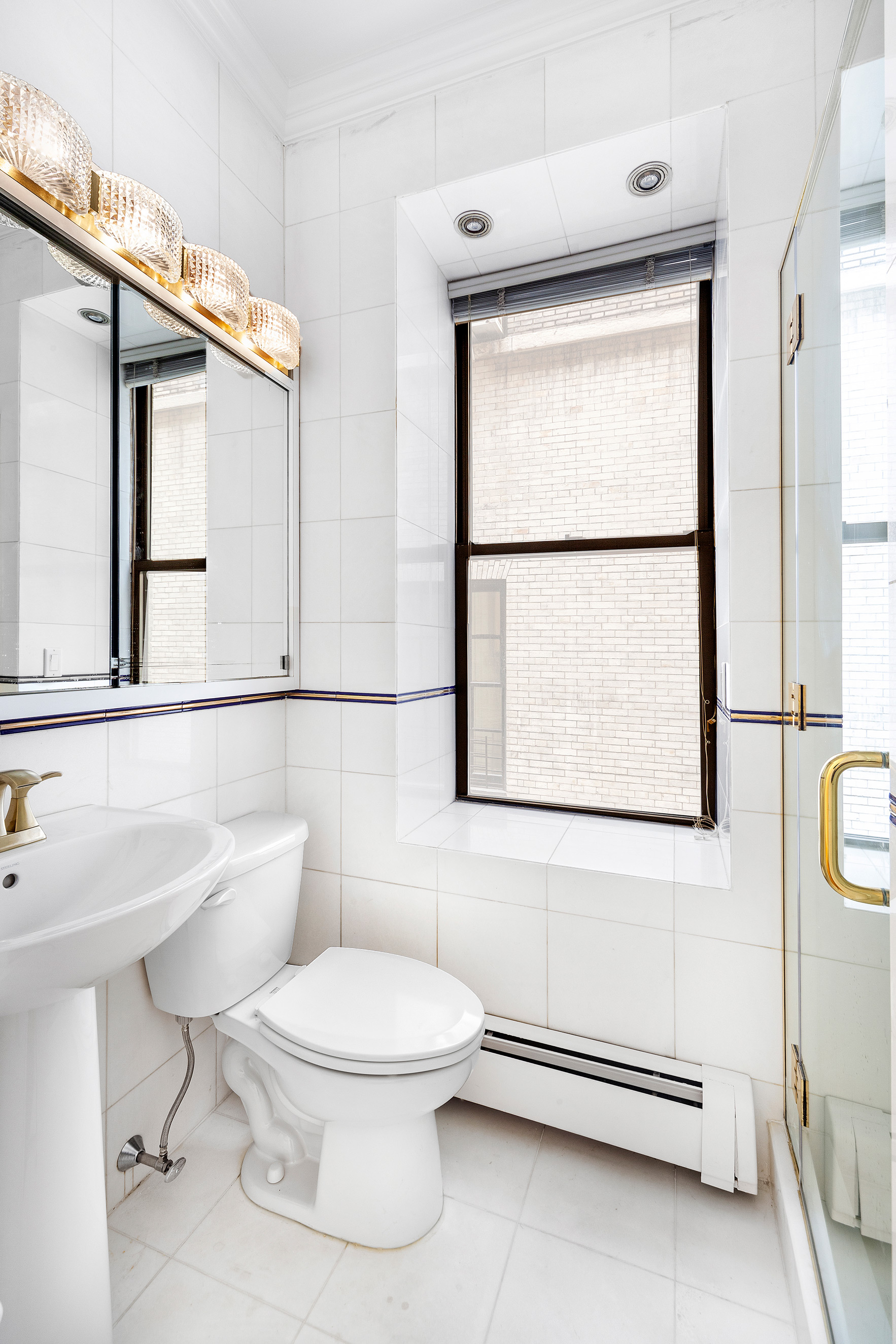 34 East 64th Street, Unit 2 Manhattan, NY 10065 - Photo 6 of 7 a white toilet sitting next to a bathroom sink