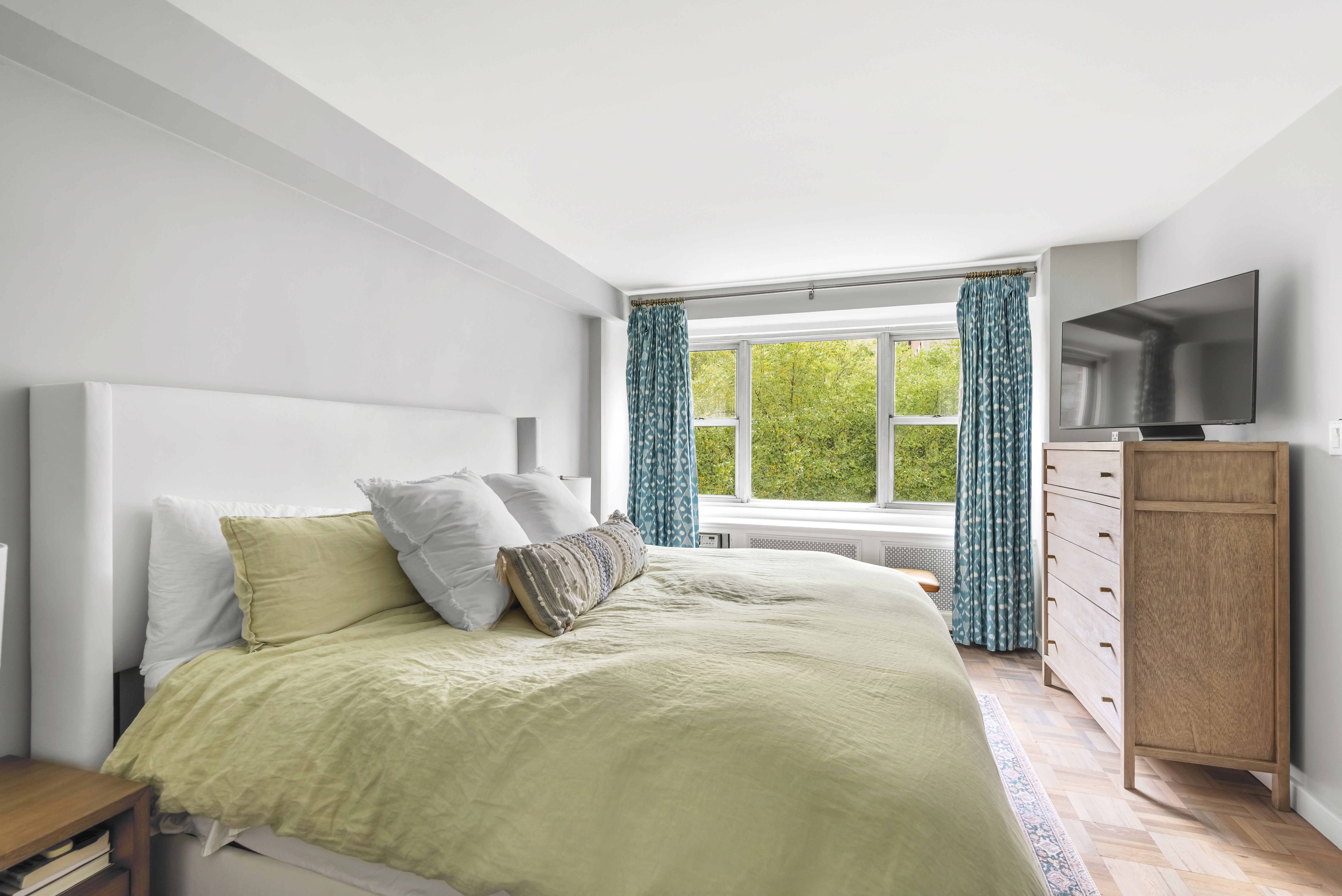 2 Charlton Street, Unit 5A Manhattan, NY 10014 - Photo 8 of 12 a bedroom with a bed flat screen tv and large window