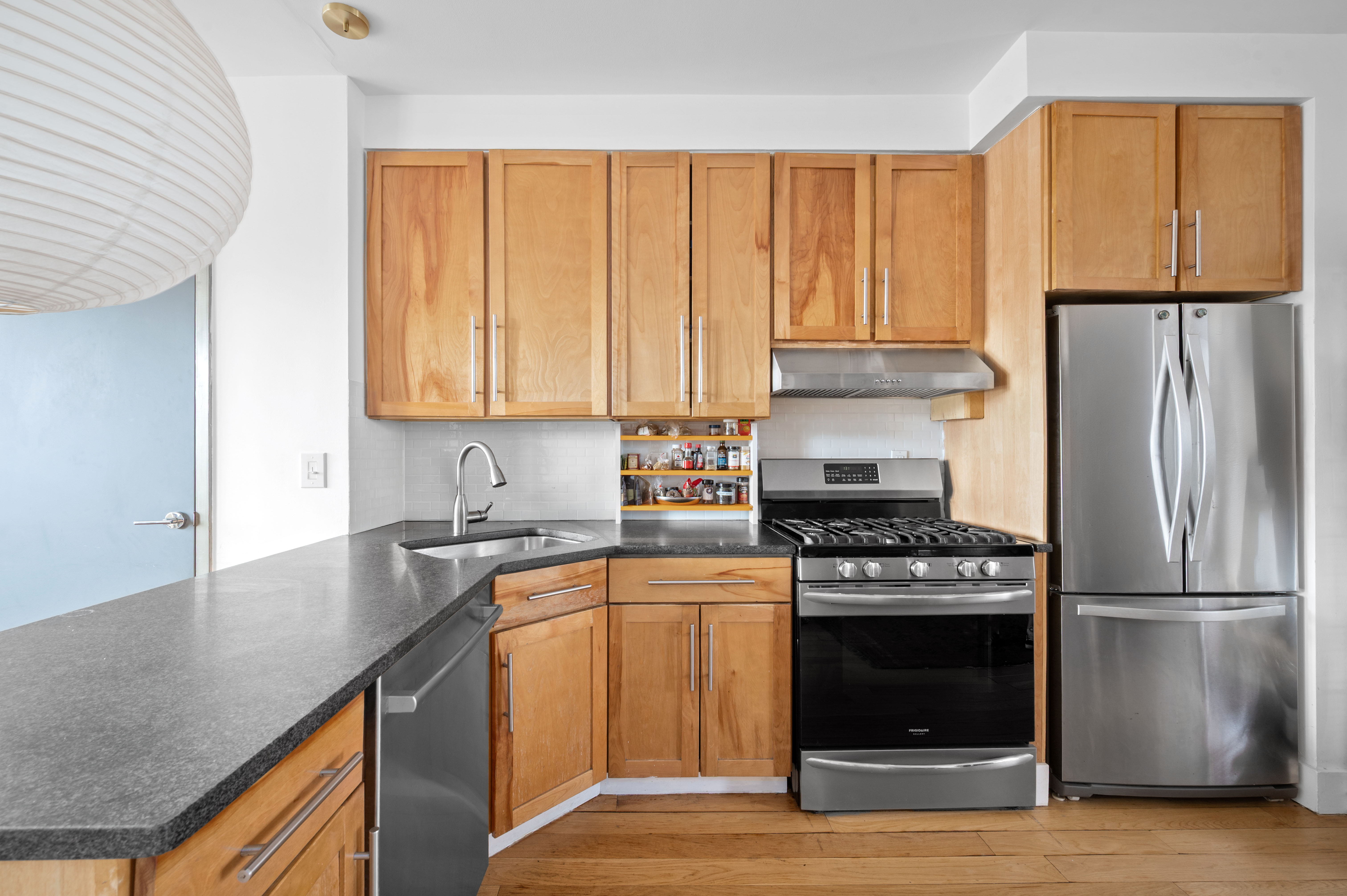 195 Spencer Street, Unit 9A Brooklyn, NY 11205 - Photo 3 of 8 a kitchen with a stove a sink and a refrigerator