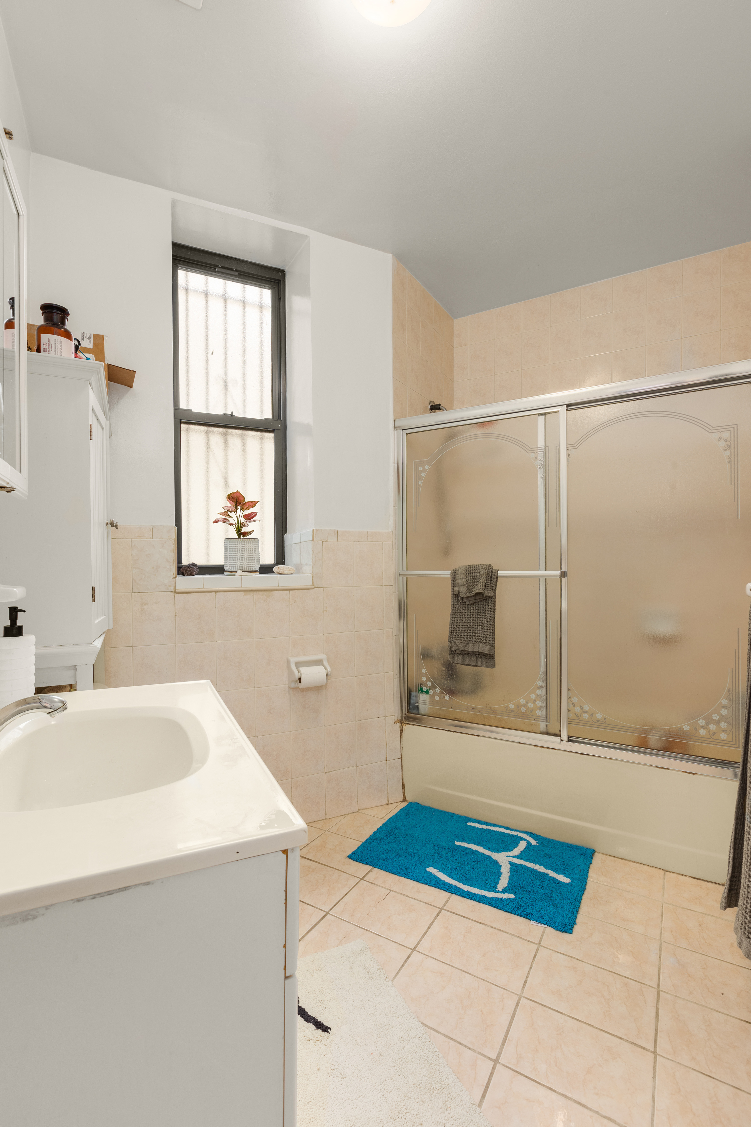 502 West 141st Street, Unit 1A Manhattan, NY 10031 - Photo 6 of 8 a bathroom with a sink a mirror and a shower