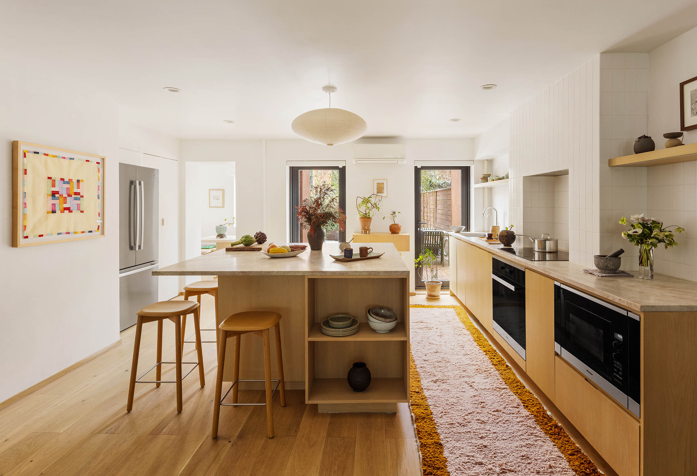 679 Putnam Avenue Brooklyn, NY 11221 - Photo 21 of 27 a large white kitchen with wooden floor and stainless steel appliances