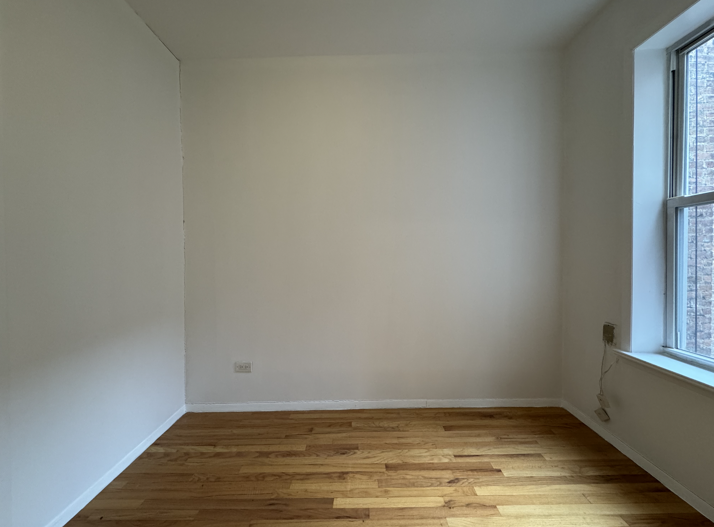 451 West 44th Street, Unit 63 Manhattan, NY 10036 - Photo 12 of 33 a view of a room with wooden floor and a window