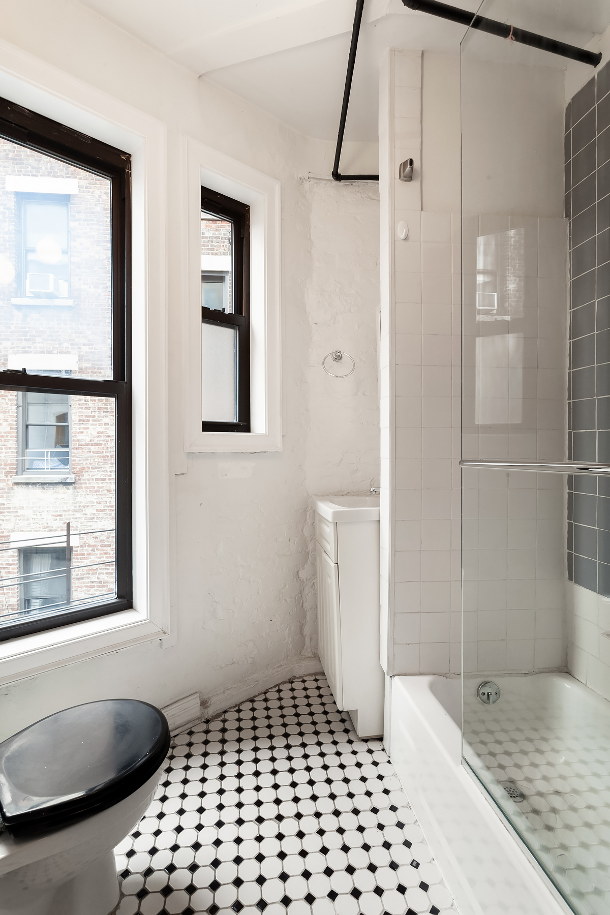 181 Thompson Street, Unit 19 Manhattan, NY 10012 - Photo 6 of 7 a bathroom with a sink a toilet a window and shower