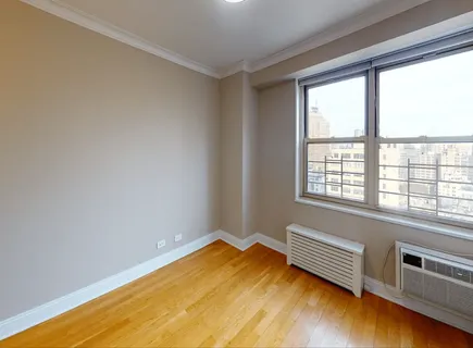 a view of a room with wooden floor and a window