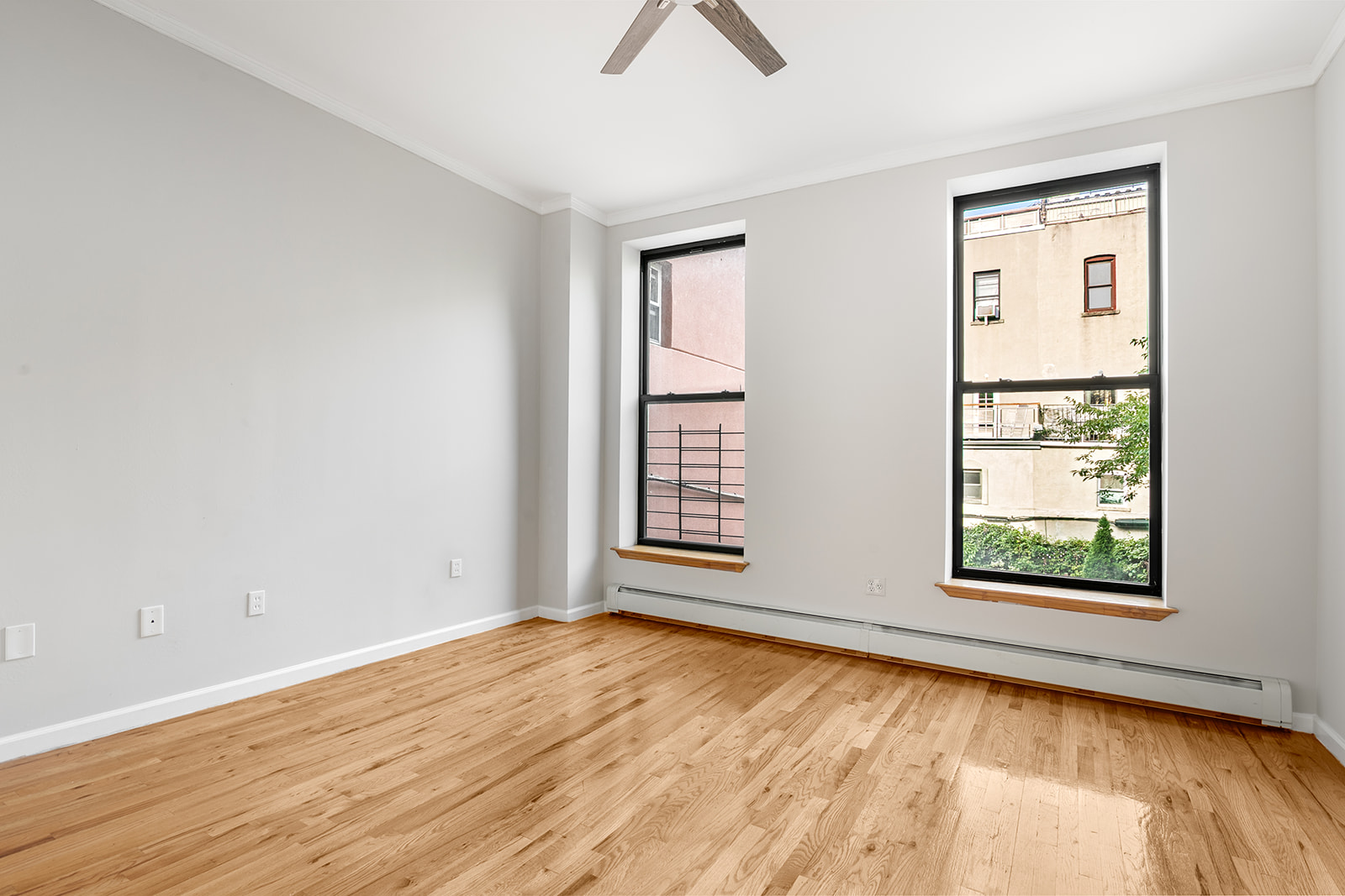 265 West 136th Street Manhattan, NY 10030 - Photo 7 of 14 a view of an empty room with wooden floor and a window