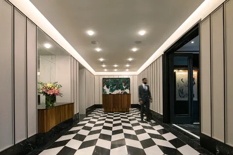a room with a black white checkered floor with a gaming machine and dining table
