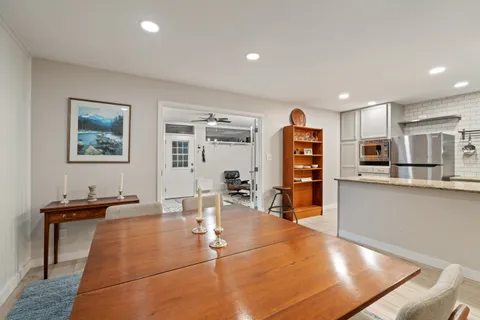 a living room with stainless steel appliances furniture and a window