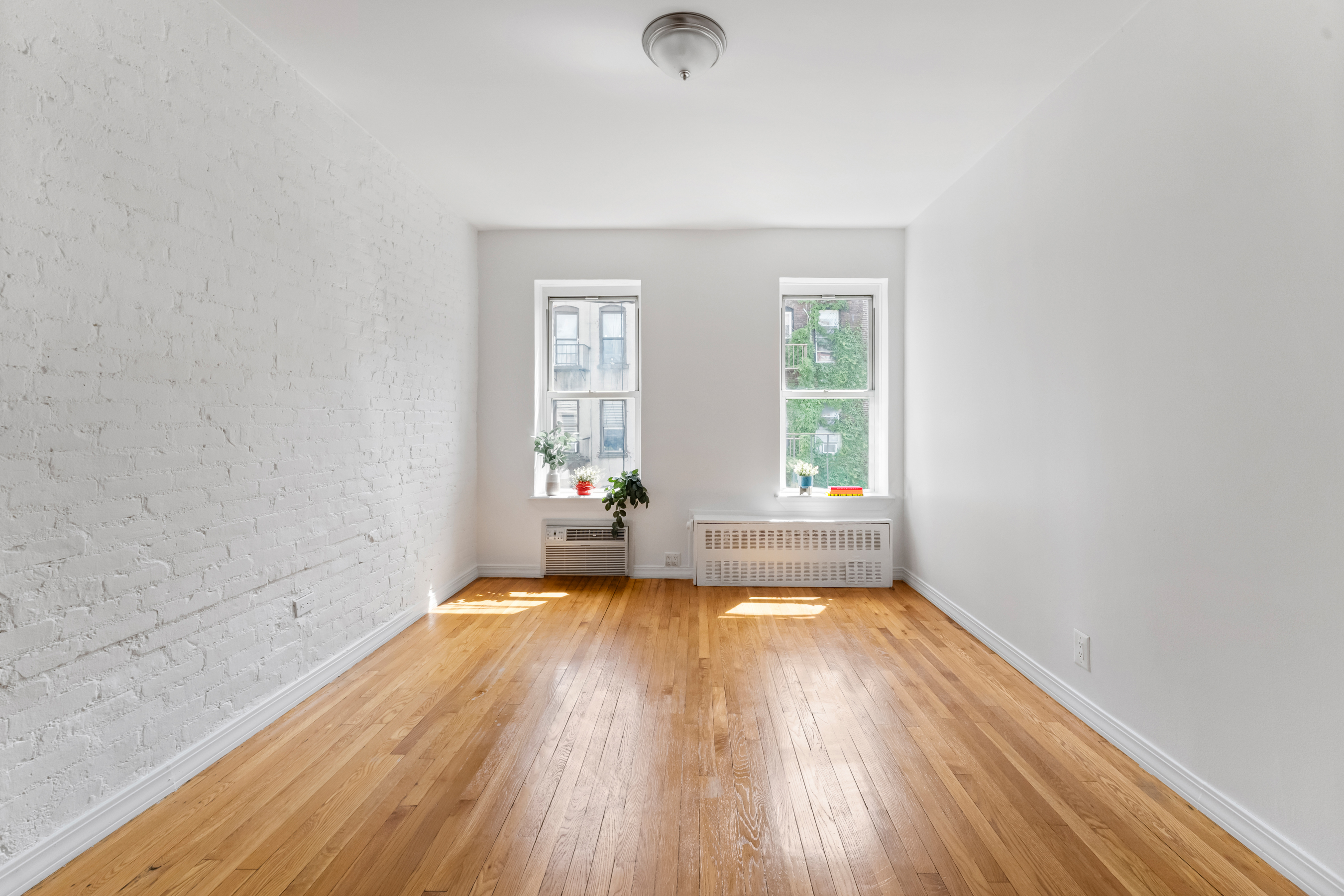 482 East 74th Street, Unit 5C Manhattan, NY 10021 - Photo 2 of 8 an empty room with wooden floor and windows