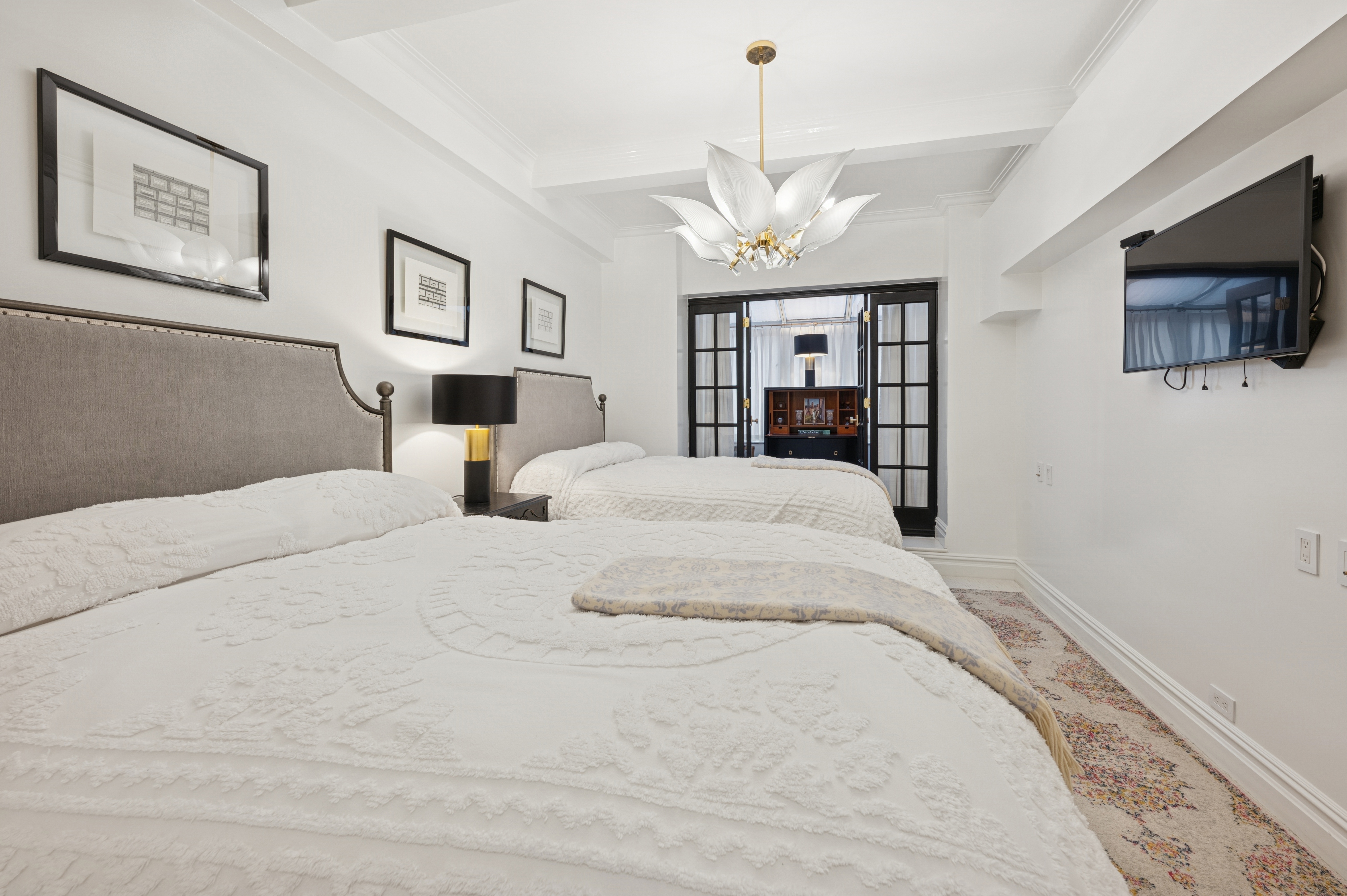 891 Park Avenue, Unit 10 Manhattan, NY 10075 - Photo 17 of 27 a bedroom with a large bed and a chandelier