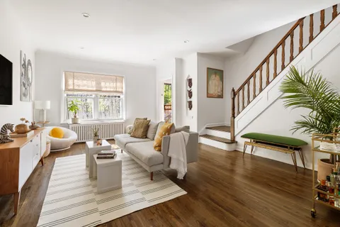 a living room with furniture fireplace and wooden floor