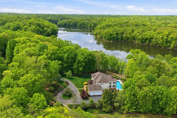 an aerial view of a house with a yard and lake view