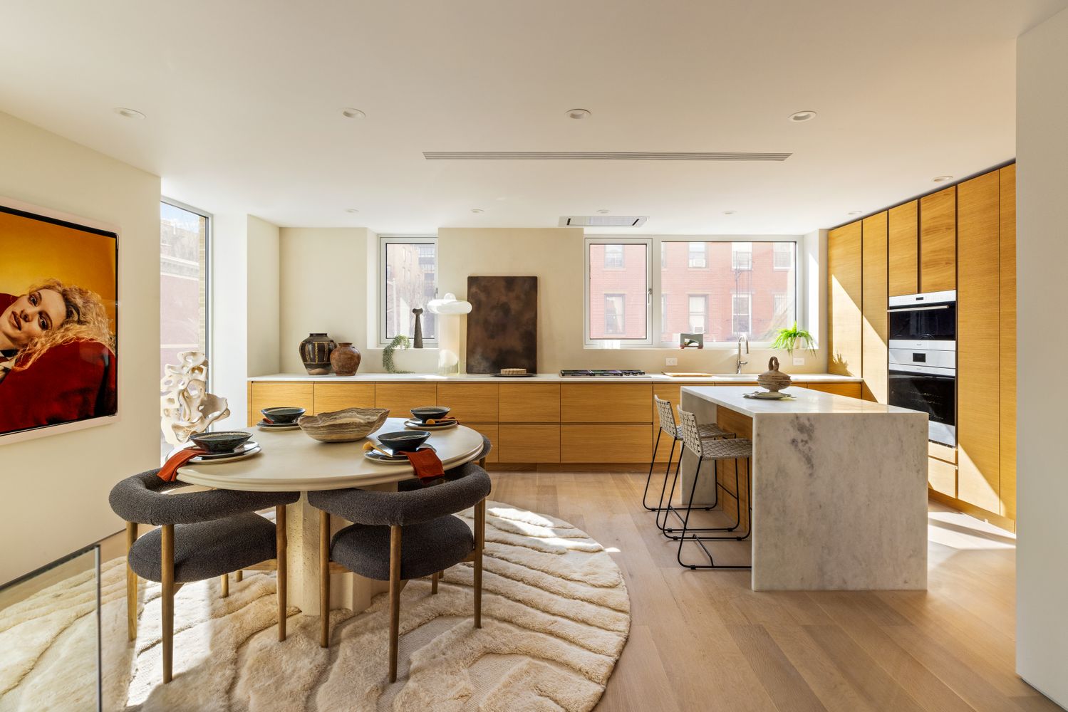 a living room with stainless steel appliances kitchen island granite countertop furniture and a large window