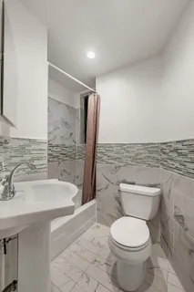 a bathroom with a sink a toilet and shower