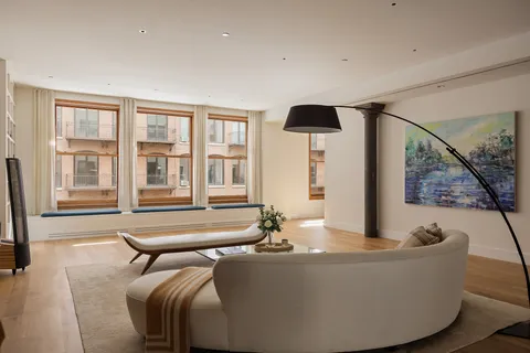 a living room with furniture and large windows