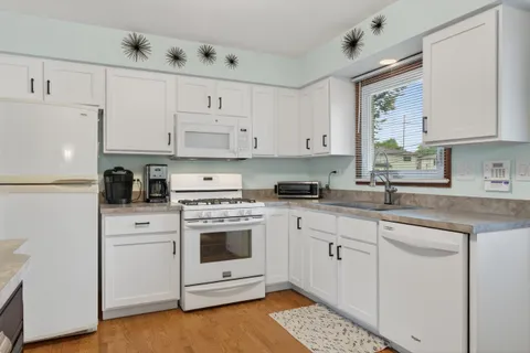 a kitchen with cabinets appliances and a window