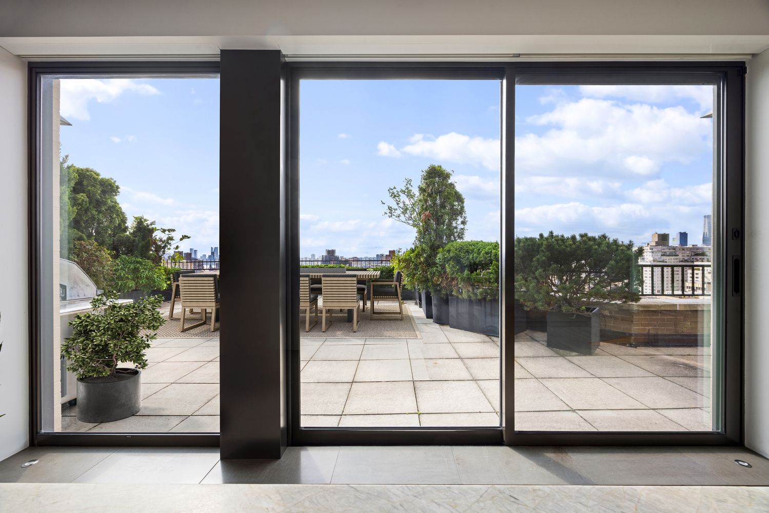 a view of a glass door with a bench in front of house