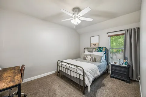 a bedroom with a bed chandelier and window
