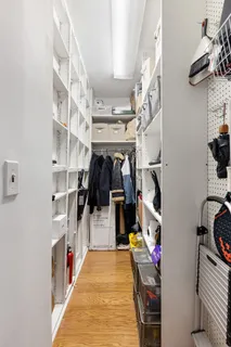 a view of walk in closet with clothes and shoes