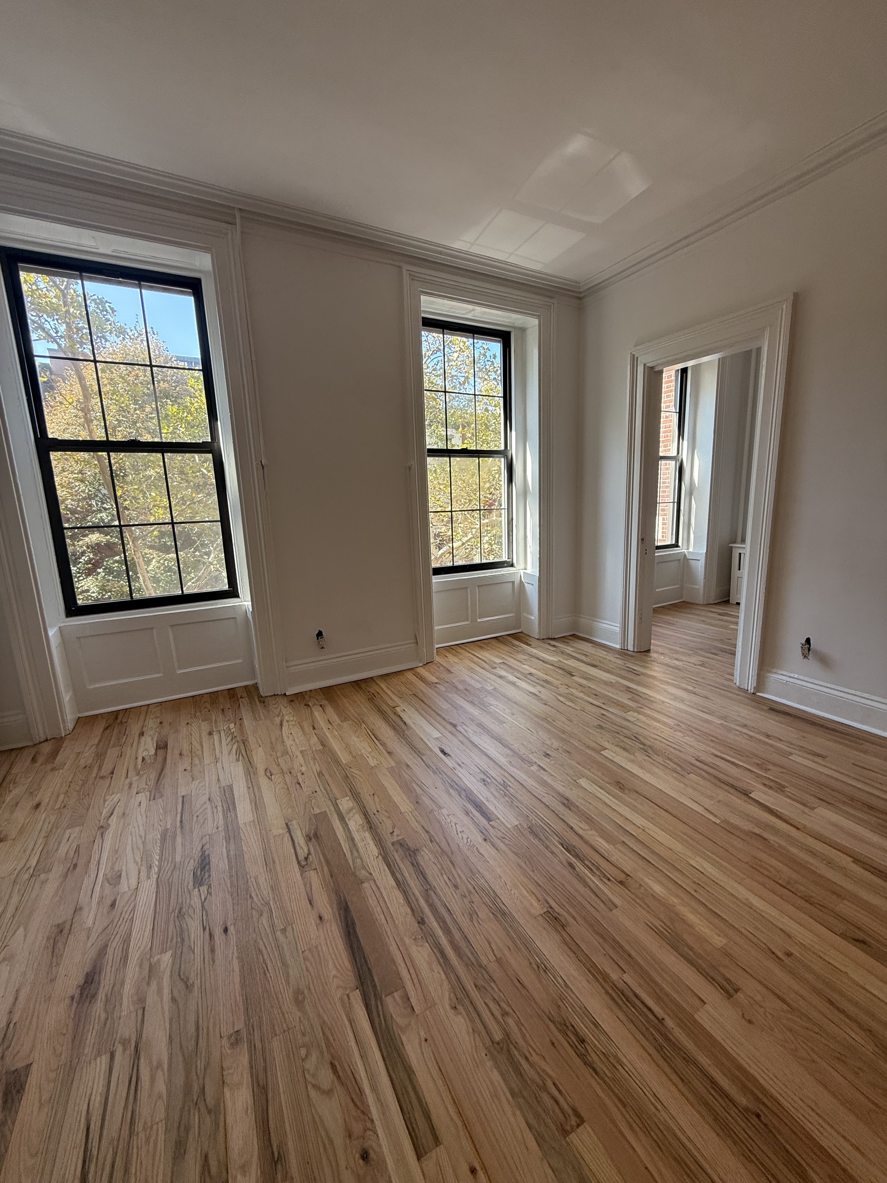 141 Summit Street, Unit 3 Brooklyn, NY 11231 - Photo 5 of 17 an empty room with wooden floor and windows