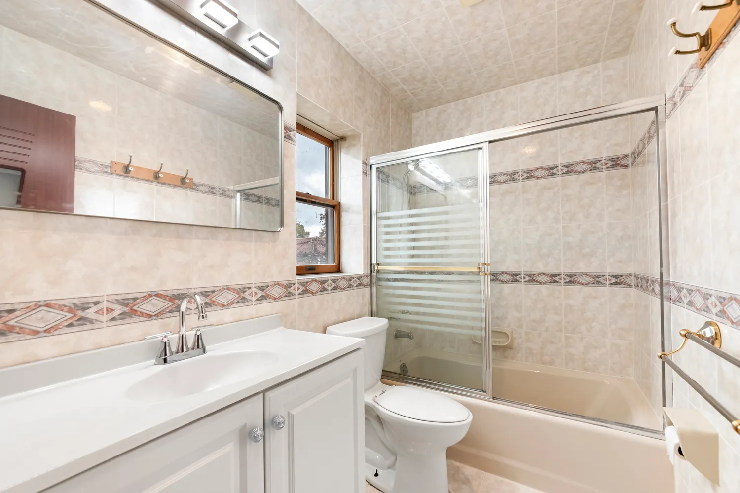 a bathroom with a sink mirror toilet and bathtub
