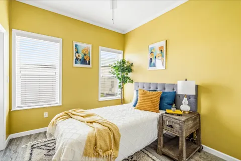 a bedroom with a bed and a potted plant