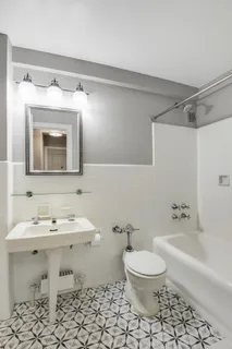 a bathroom with a toilet sink and mirror