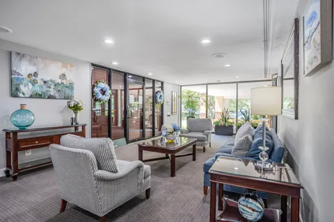 a living room with furniture and a floor to ceiling window