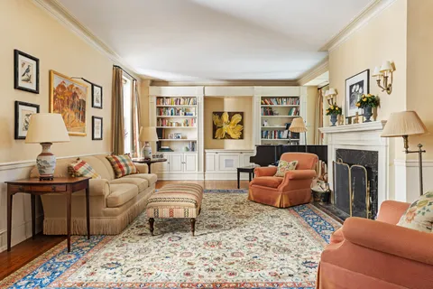 a living room with furniture large window and wooden floor