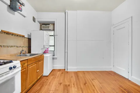 a kitchen with a sink cabinets and wooden floor