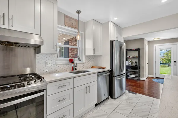 a kitchen with stainless steel appliances granite countertop a stove and a refrigerator