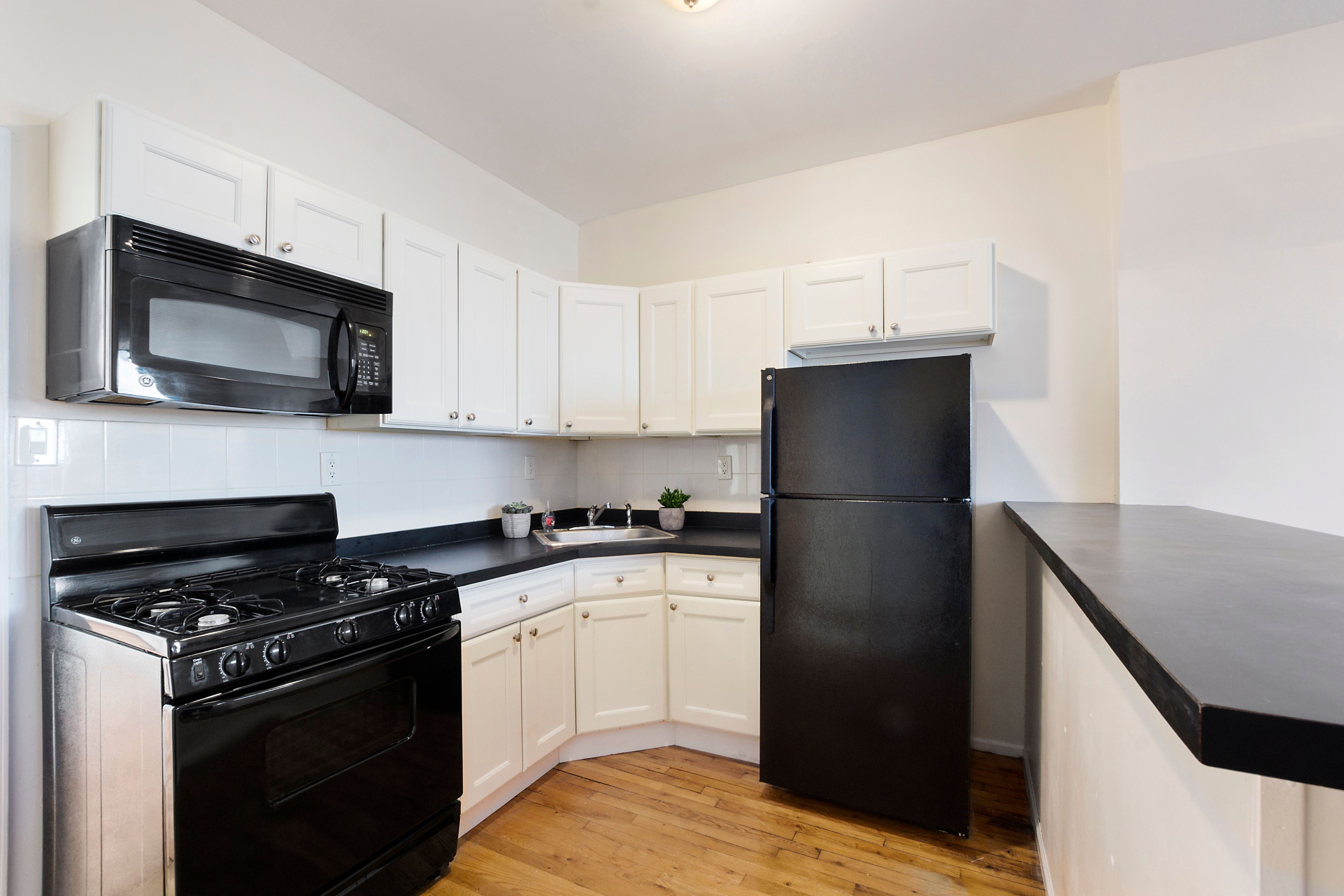 148 29th Street Brooklyn, NY 11232 - Photo 20 of 31 a kitchen with a sink stove and microwave