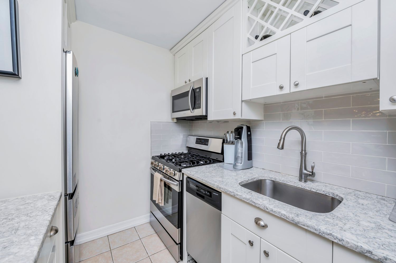 333 East 79th Street, Unit 2R Manhattan, NY 10075 - Photo 6 of 13 a kitchen with granite countertop a sink stainless steel appliances and cabinets