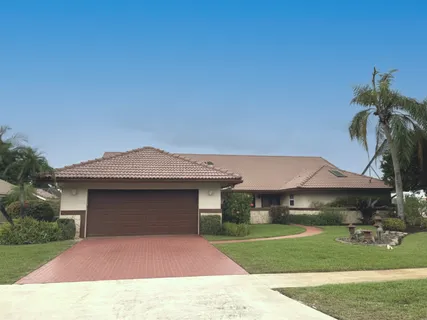 a front view of a house with a garden and yard