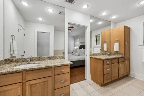 a bathroom with a granite countertop tub sink and mirror