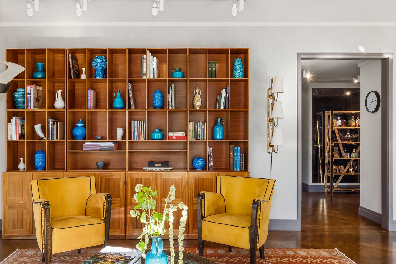 a living room with furniture cabinets and wooden floor