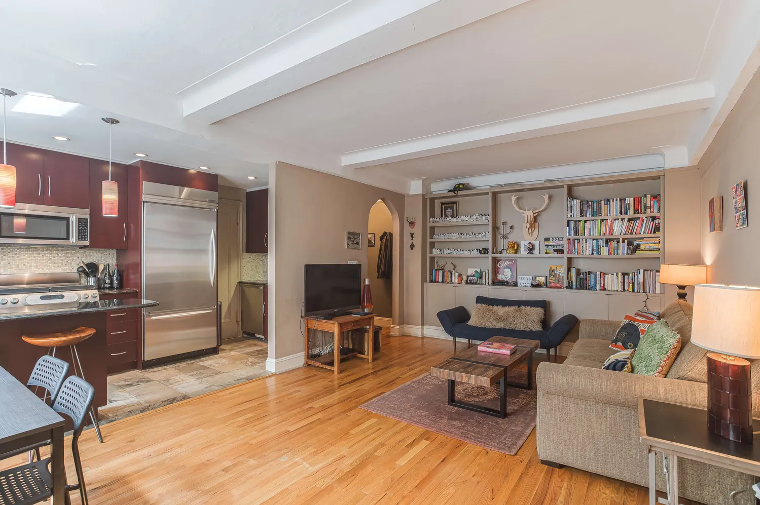 a work room with furniture wooden floor and a view of kitchen