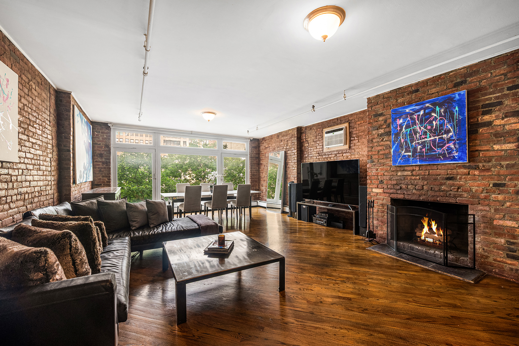12 West 29th Street, Unit 4 Manhattan, NY 10001 - Photo 2 of 13 a living room with furniture a flat screen tv and a fireplace