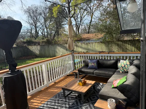 a balcony with wooden floor and outdoor seating