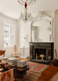 a living room with a fireplace windows and a chandelier
