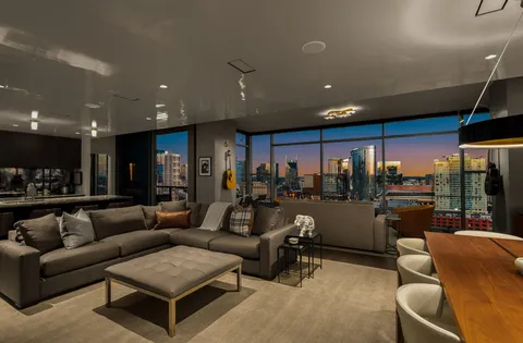 a living room with furniture and a view of kitchen