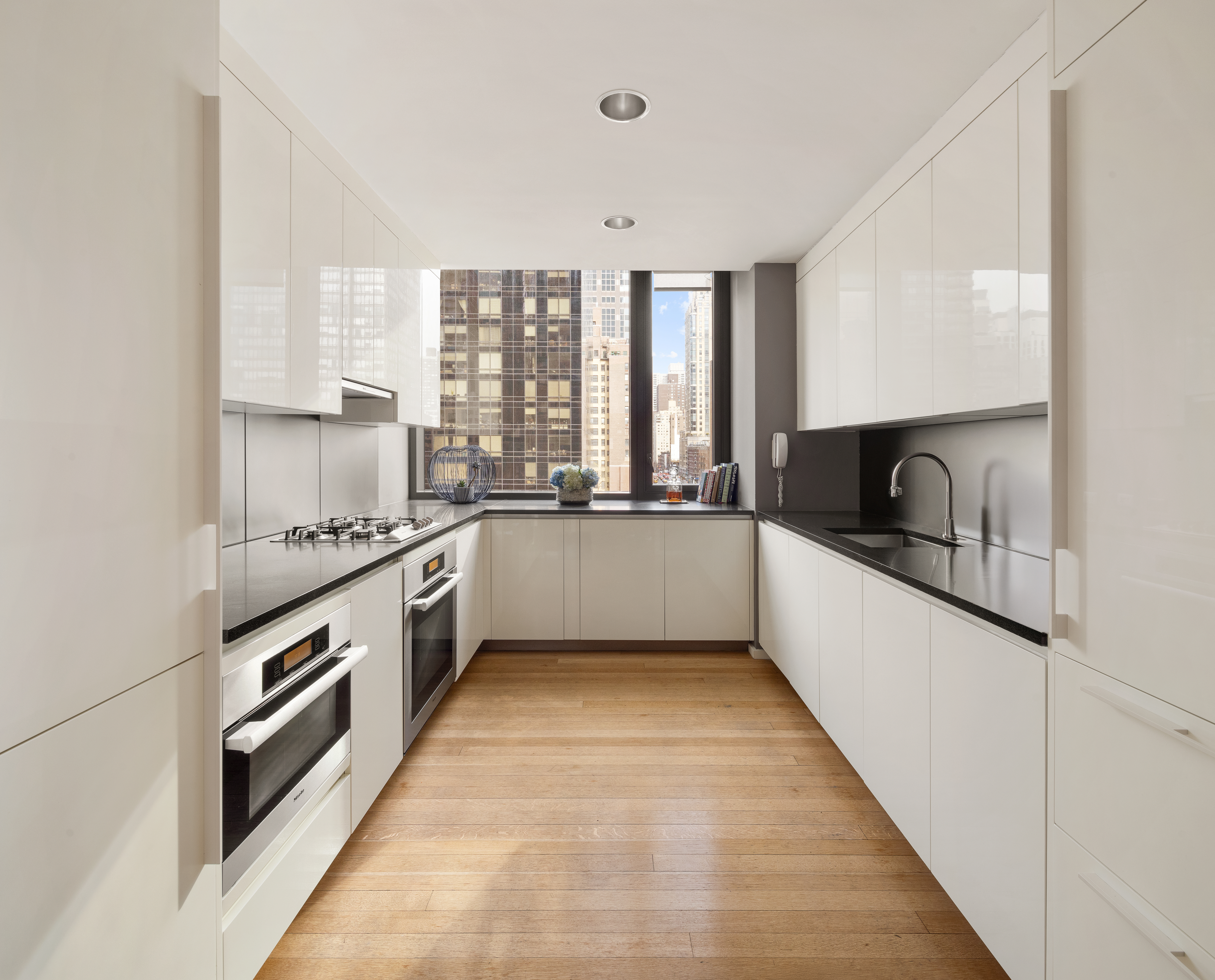 50 United Nations Plaza, Unit 6B Manhattan, NY 10017 - Photo 6 of 13 a kitchen with granite countertop a sink and a stove top oven