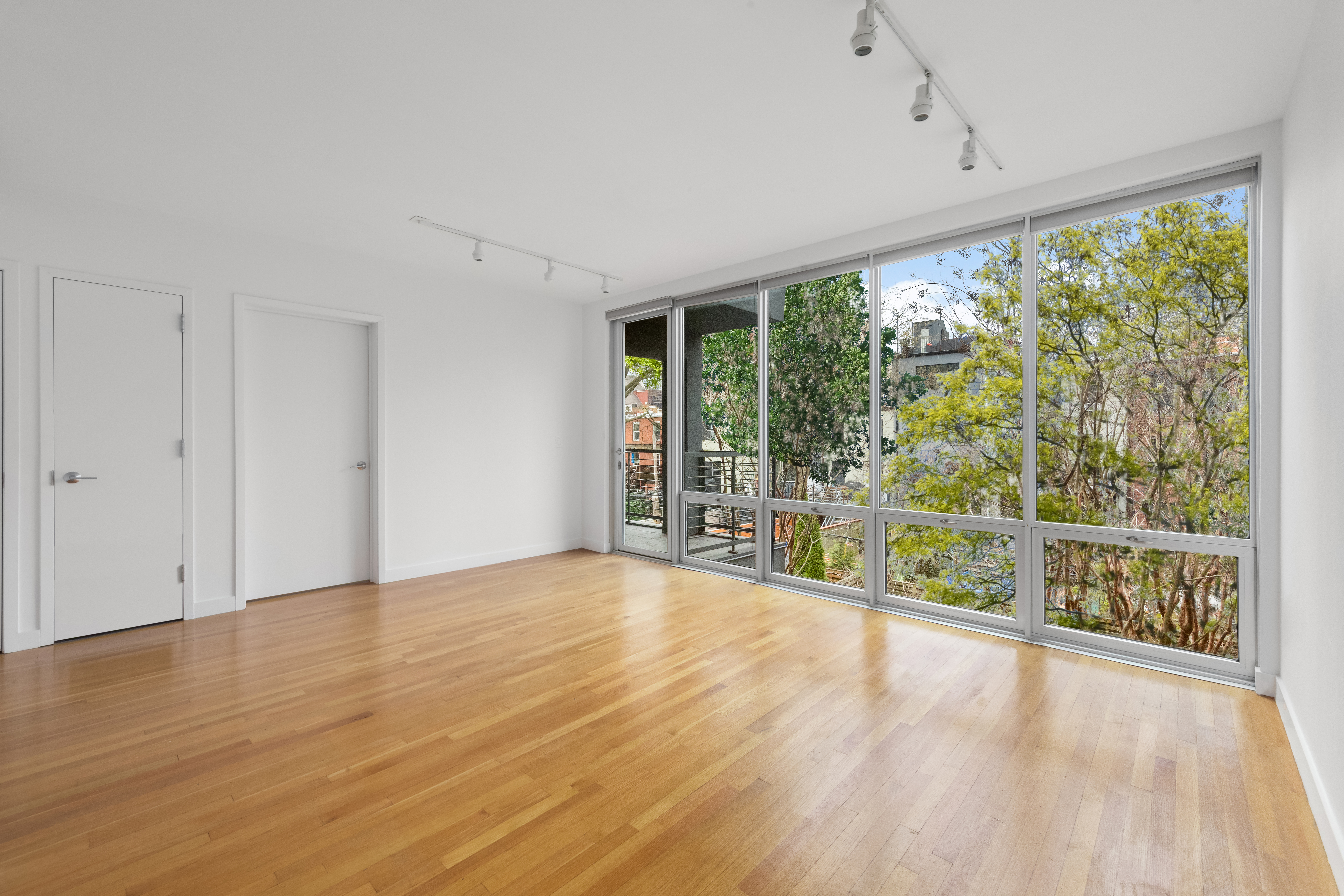 232 7th Street, Unit 3B Brooklyn, NY 11215 - Photo 2 of 7 a view of an empty room with wooden floor and a window