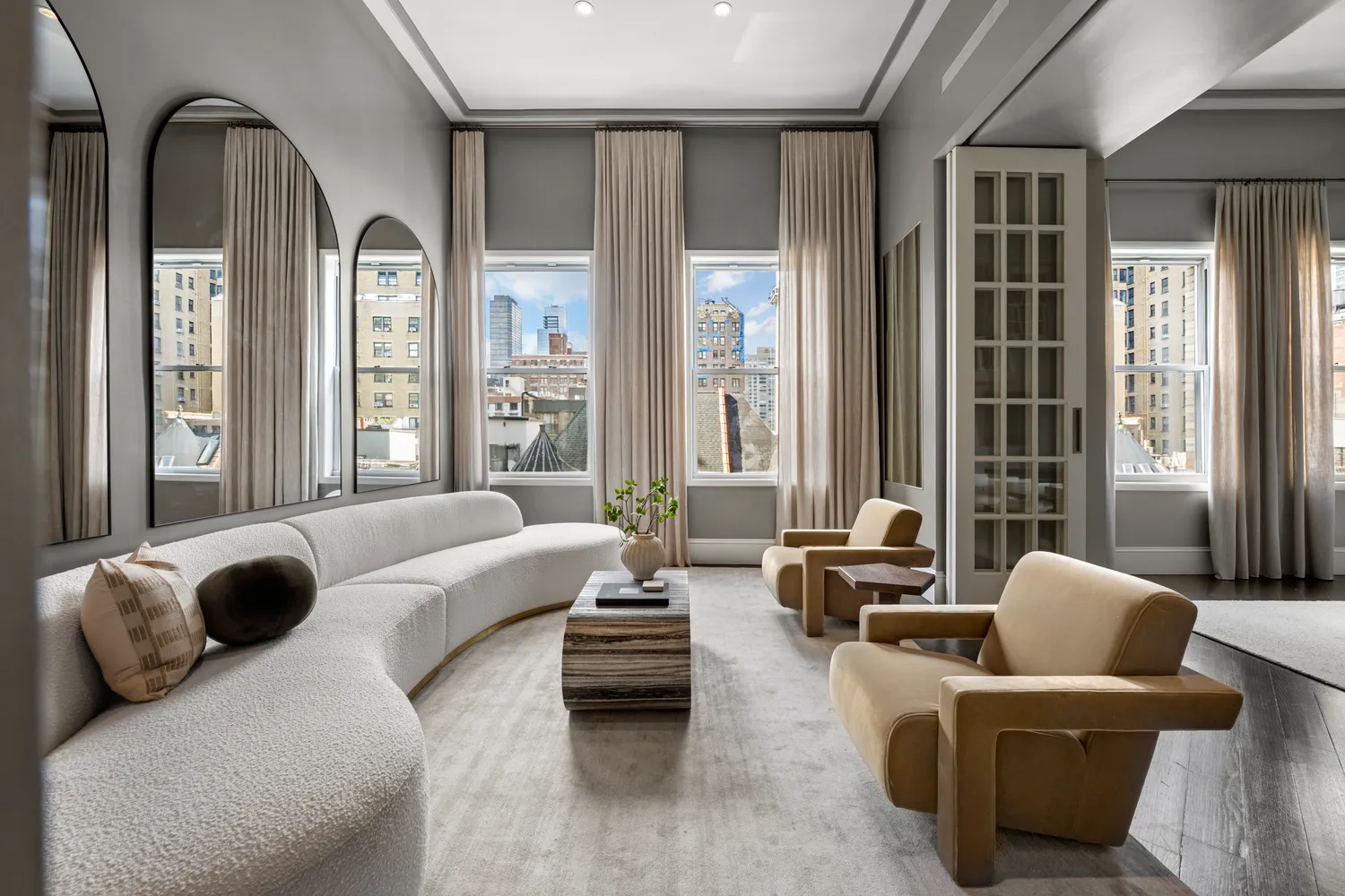 a living room with furniture and floor to ceiling windows